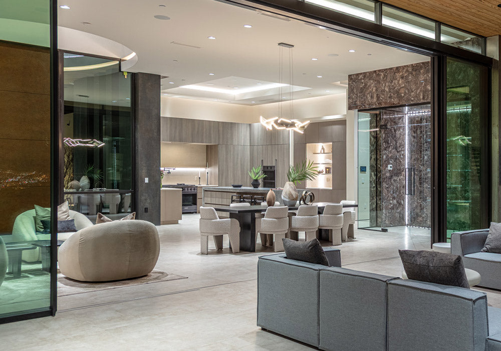 Contemporary living and dining space with integrated lighting and a wall-mounted control panel